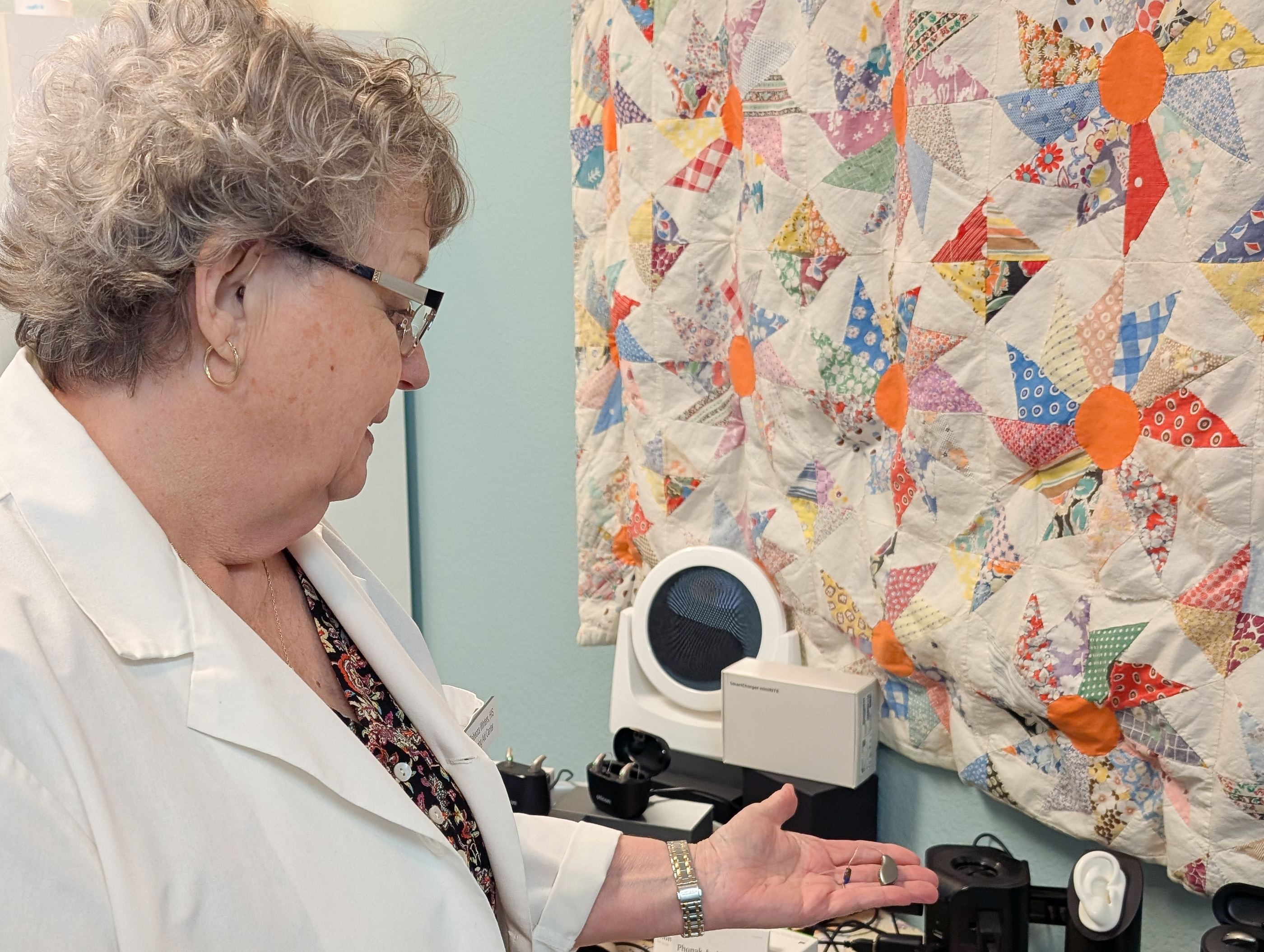 Rebecca Winters HIS showing a hearing aid to a patient during a fitting at Hearing Aid Center Ocean Park Washington